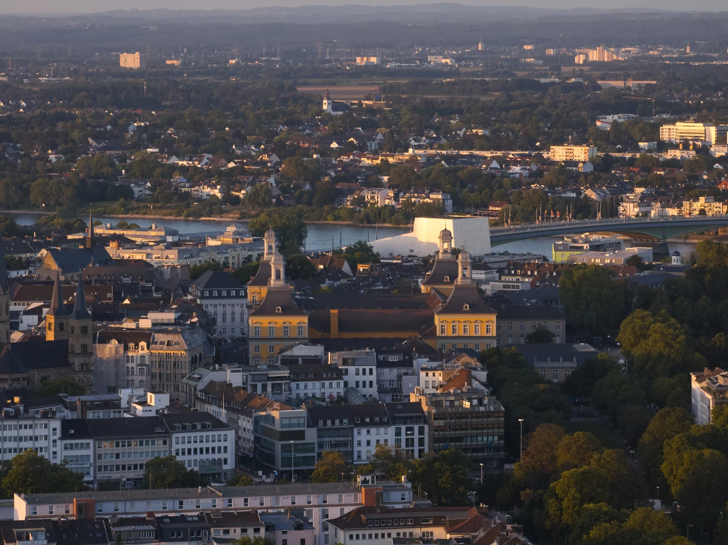 Eine Wissenschaftlerin und ein Wissenschaftler arbeiten hinter einer Glasfassade und mischen Chemikalien mit Großgeräten.